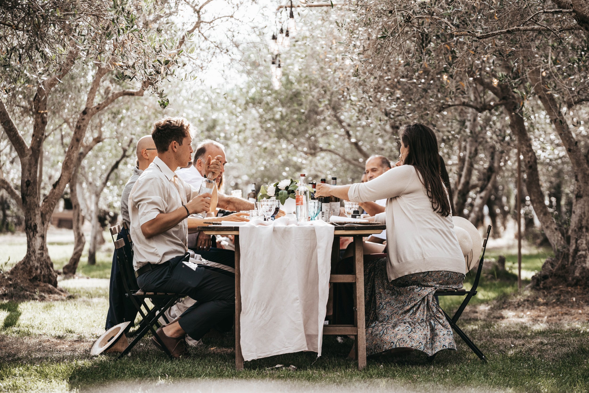 Hochzeitsgäste an einer festlich gedeckten Tafel im Freien